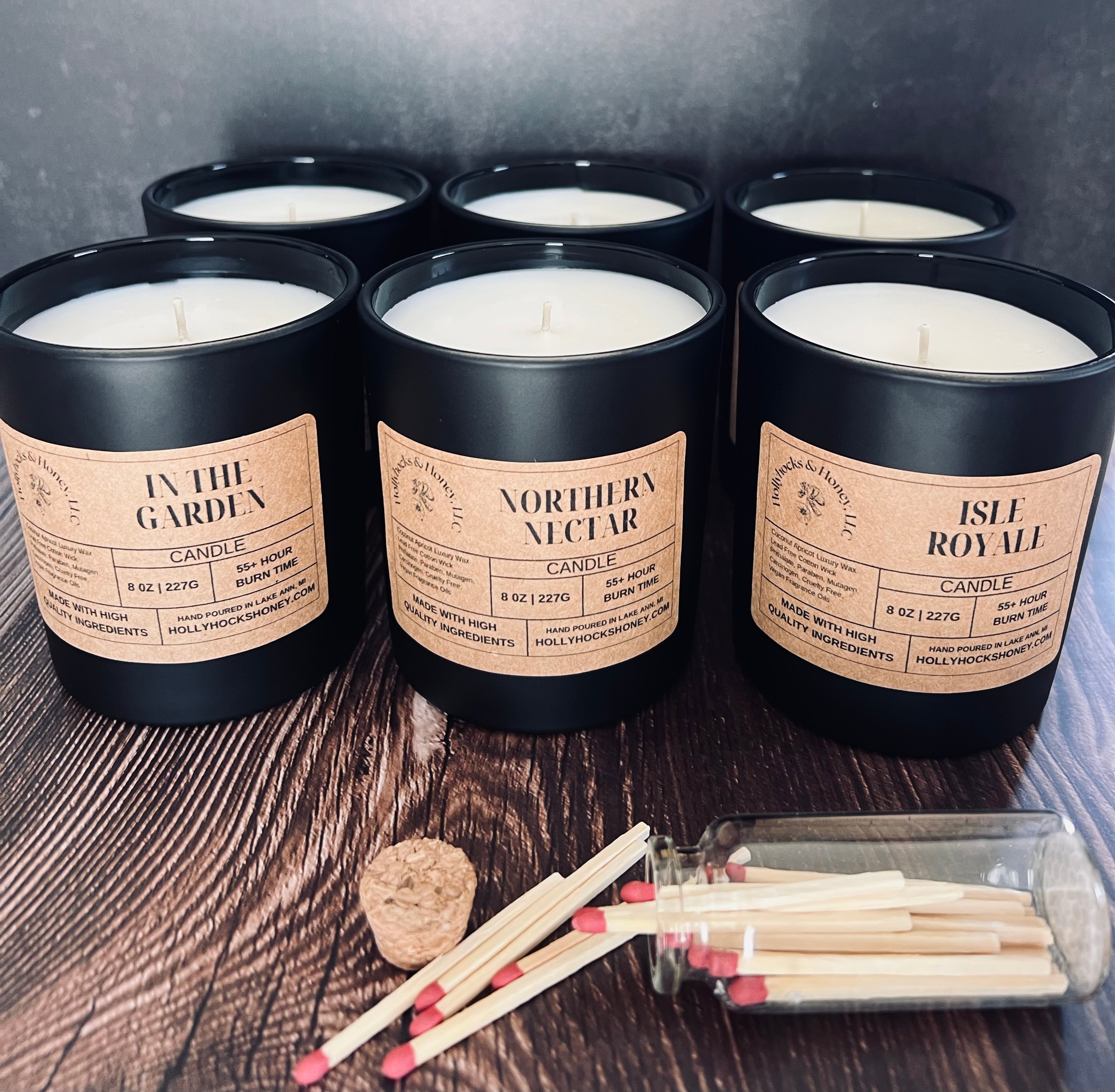 Five candles with labels on a wooden surface with matches and cork.